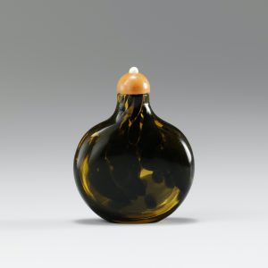 Dark brown dapples with pale brownish-orange glass of flattened form