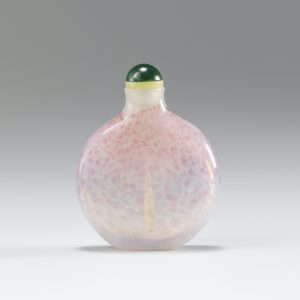 Pink dapples on white glass of flattened form